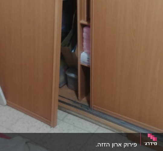 ארון עץ עם דלתות הזזה פתוחות חלקית